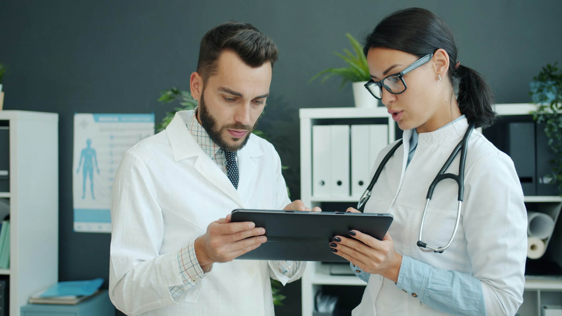 Clinicians using a tablet to coordinate patient workflow